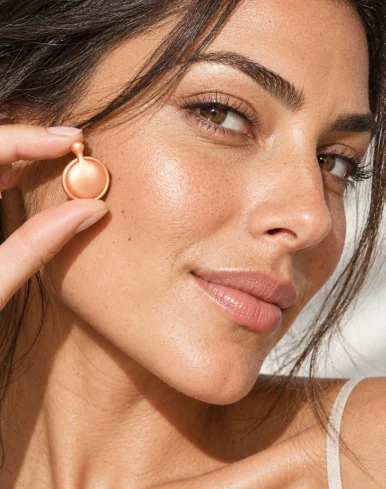 Mujer sosteniendo una cápsula twist-off junto a su rostro